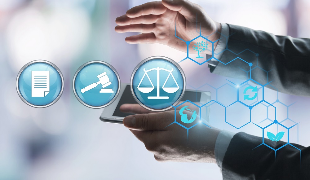 A person in a suit holds a tablet while hovering their hands above it. Icons representing legal documents, a gavel, and scales of justice surround the tablet, symbolizing themes of law and justice, with abstract shapes in the background.