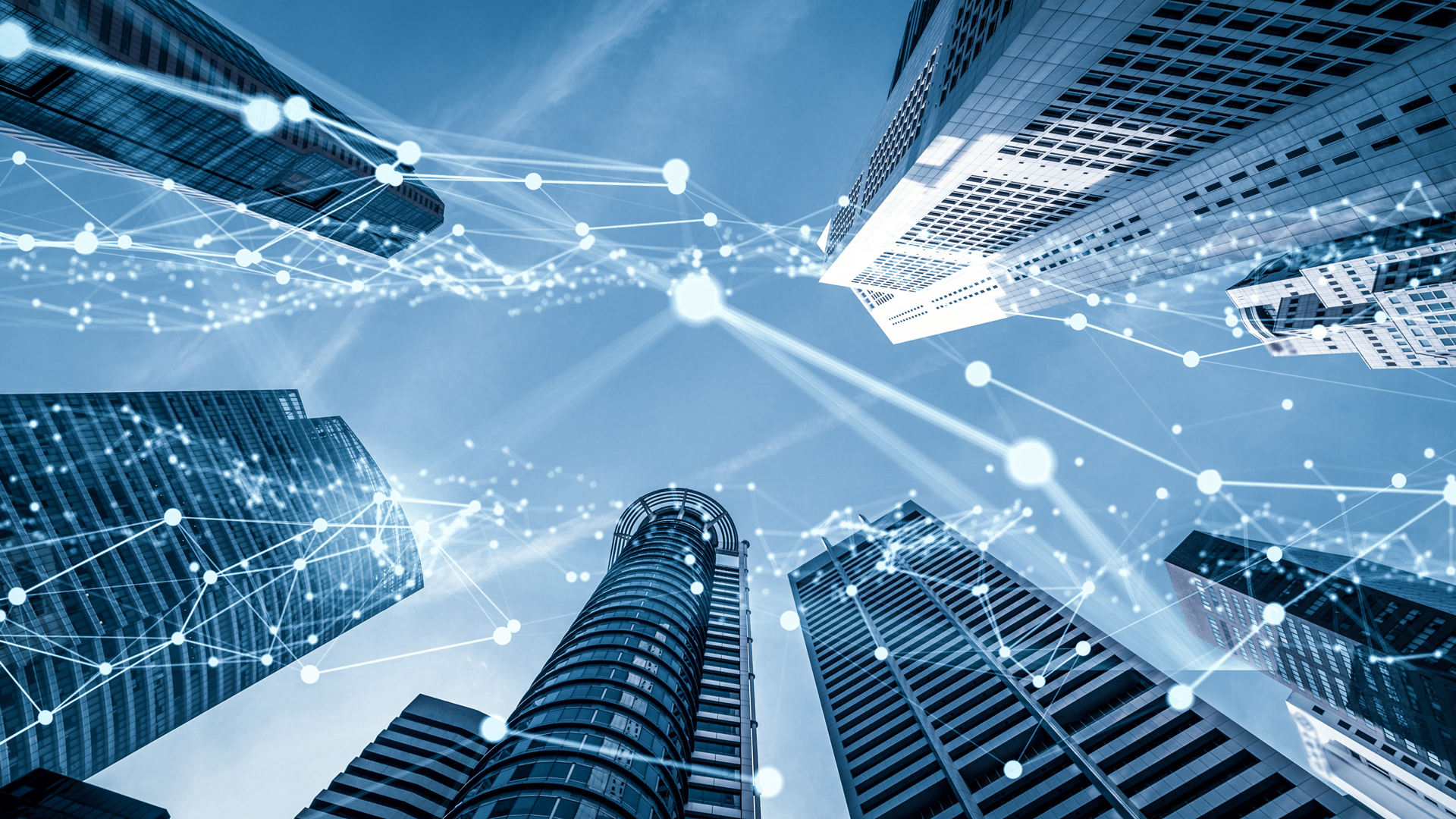 Bank guarantees: options for the guarantee creditor A view looking up between tall skyscrapers with a blue sky above. There are digital connecting lines and nodes overlaying the buildings, symbolizing technology and connectivity in an urban environment.